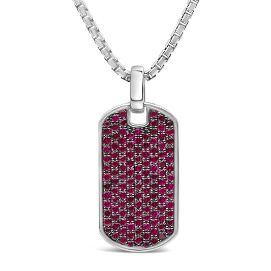 Front-facing close-up of a white metal dog tag style necklace pendant covered with round red gemstones in a shared prong setting.
