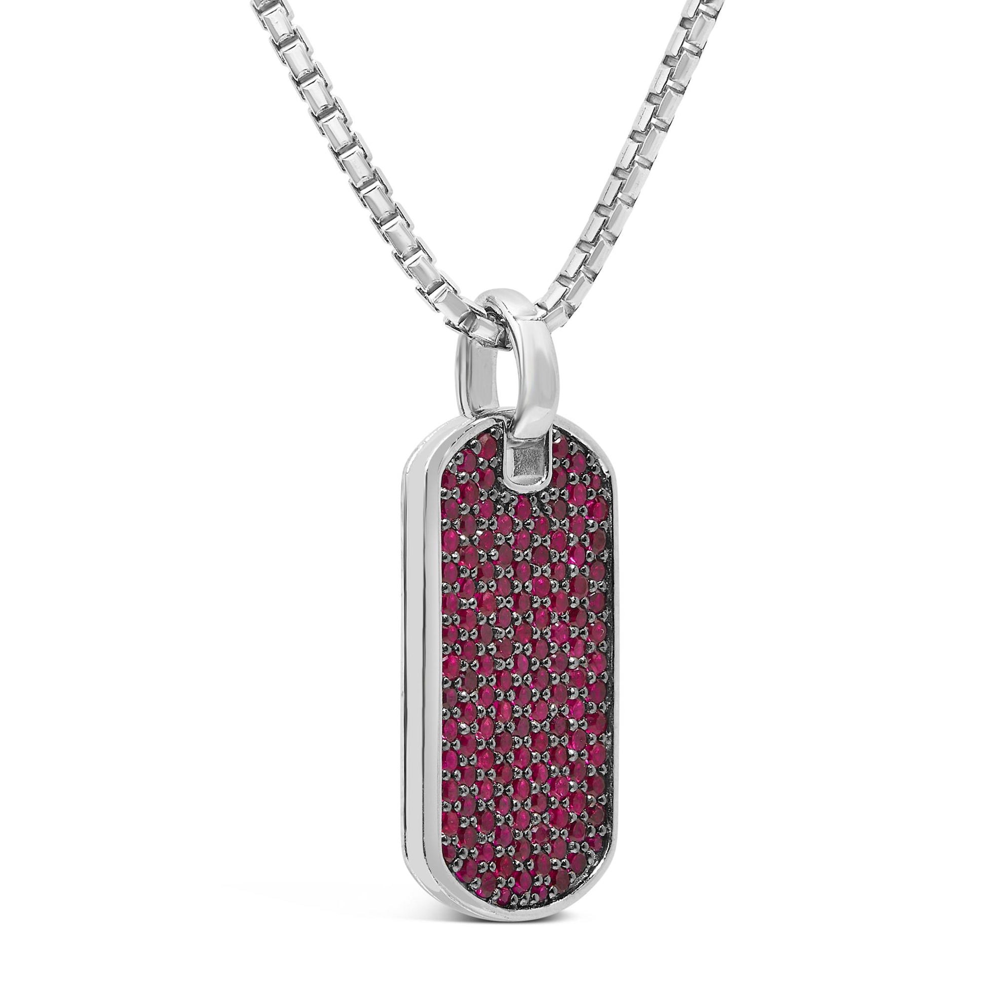 Close-up front angle of a white necklace with a rectangular pendant featuring multiple small round red gemstones in a shared prong setting.