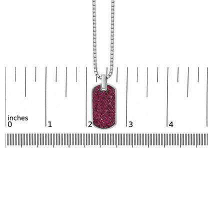 Front-facing close-up of a white metal necklace with a rectangular pendant encrusted with round red gemstones, shown on a ruler scale.