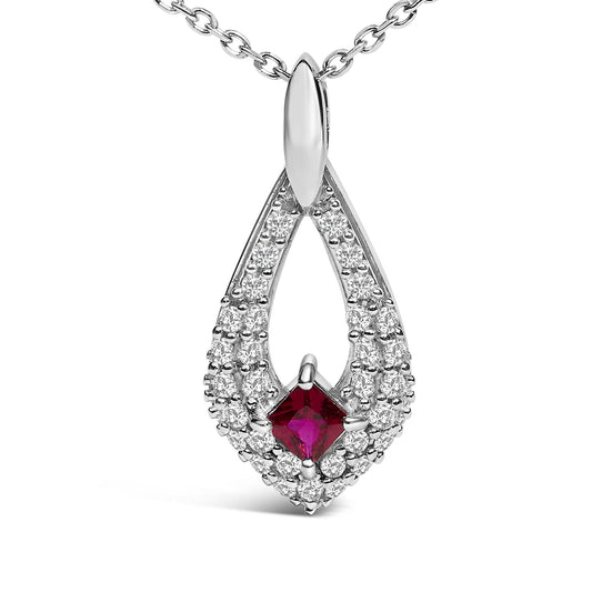 Close-up front view of a white metal necklace pendant with a teardrop shape featuring a princess-cut red gemstone in the center surrounded by multiple round white gemstones, shown on a white background.