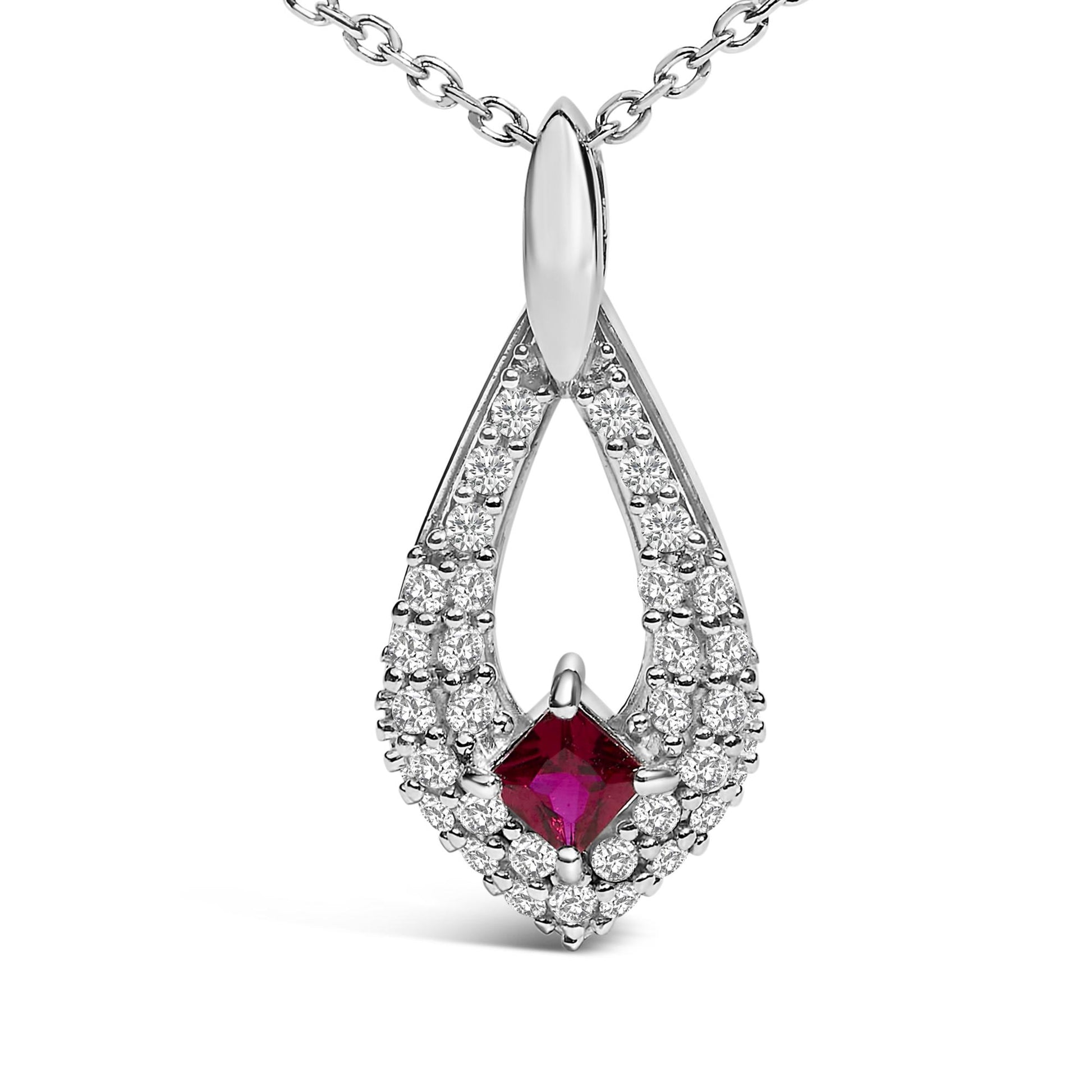 Close-up front view of a white metal necklace pendant with a teardrop shape featuring a princess-cut red gemstone in the center surrounded by multiple round white gemstones, shown on a white background.