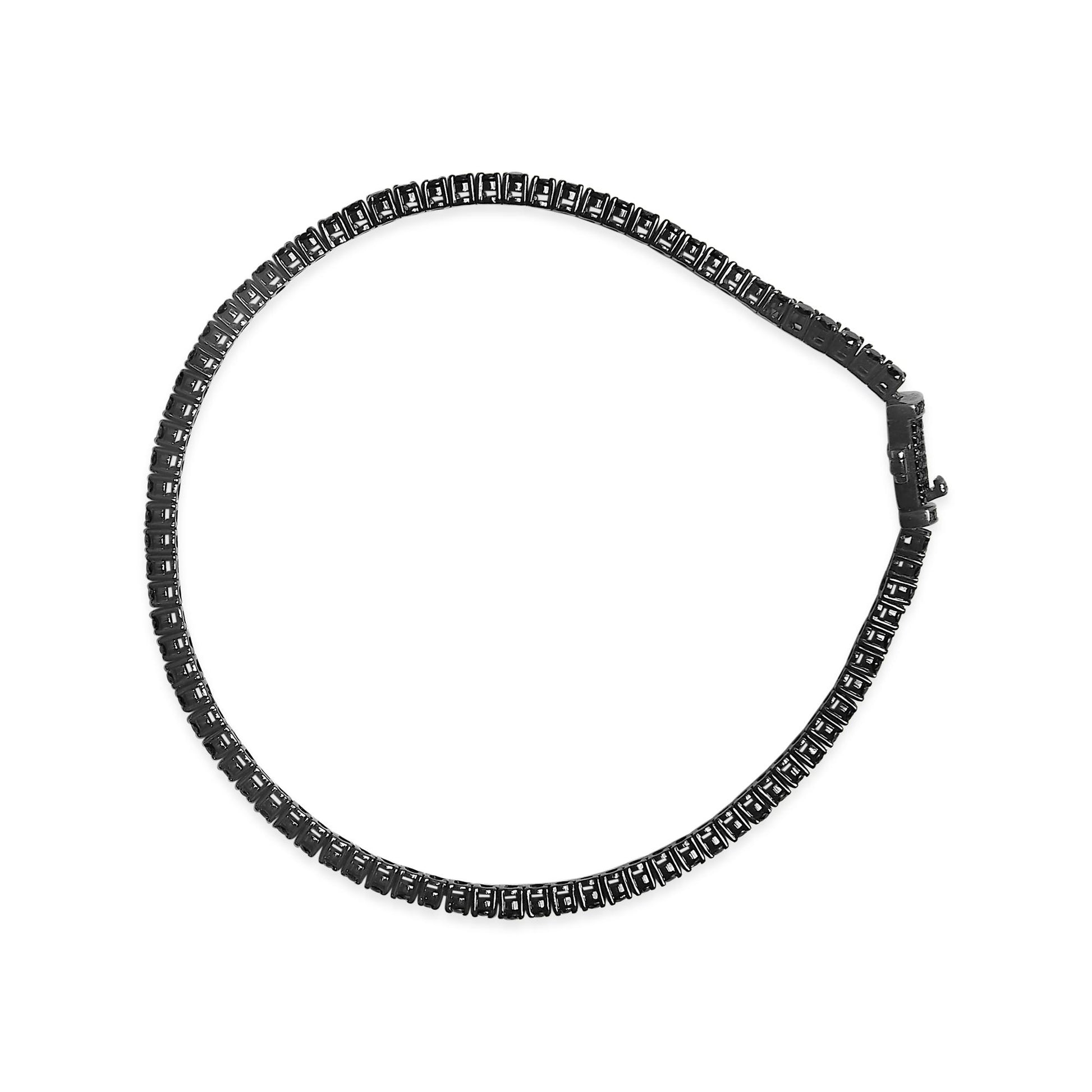 Top-down view of a white metal bracelet with black round gemstones in prong settings, laid flat showing the clasp.