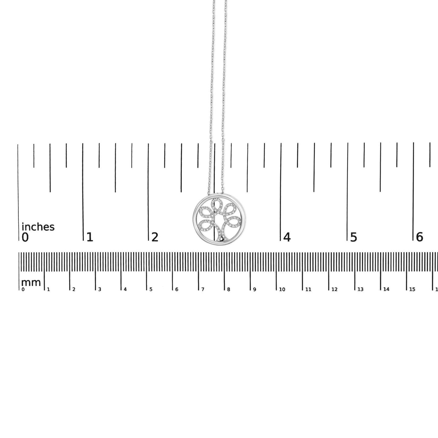 White metal necklace with a round pendant featuring a tree design adorned with white round gemstones in 4-prong settings, displayed flat on a ruler for size reference, shot from above.