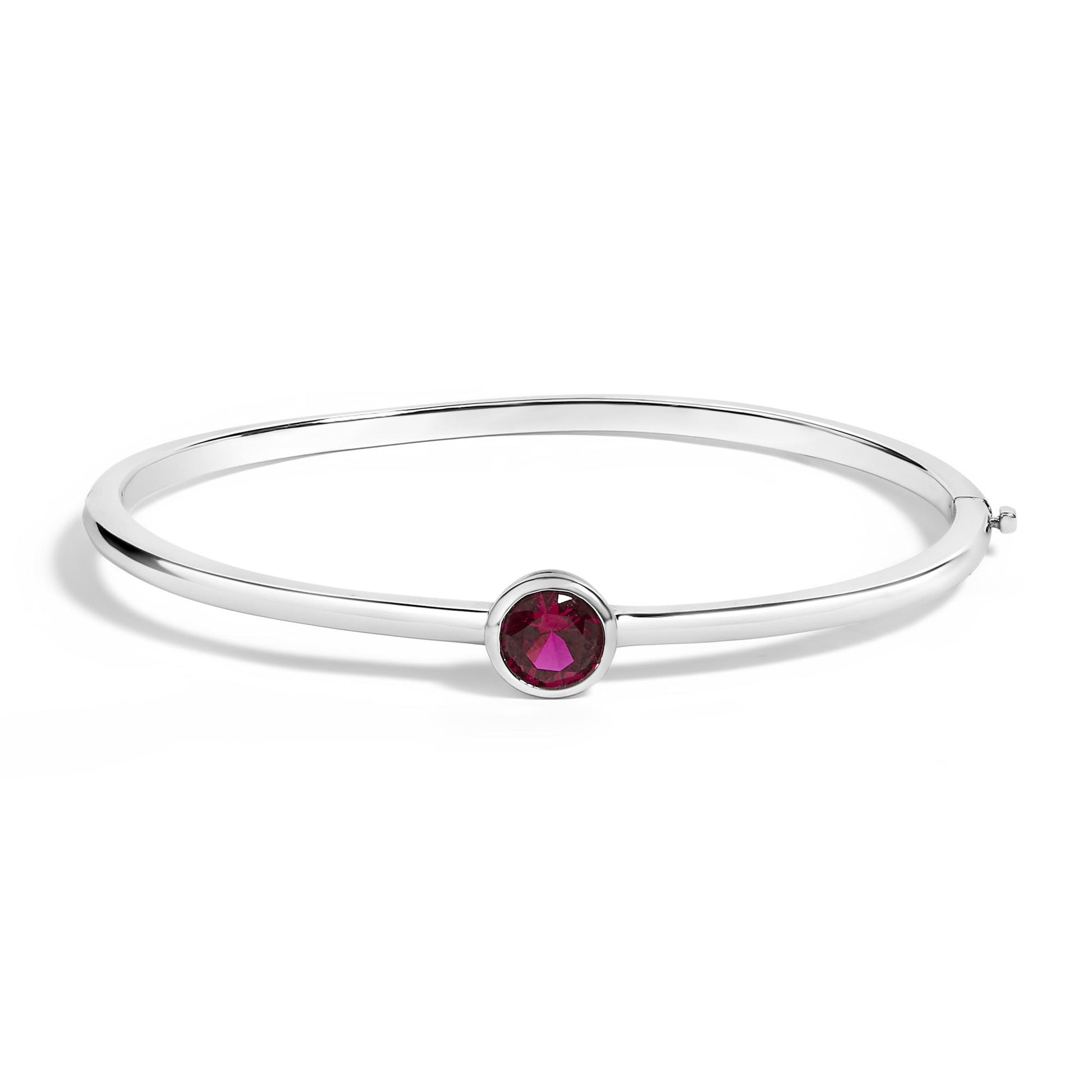 White bracelet with a round red gemstone in a bezel setting, shown in a side angled view on a white background.