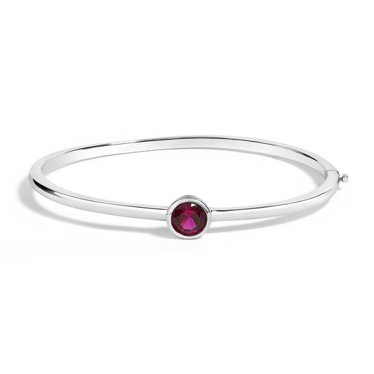 White bracelet with a round red gemstone in a bezel setting, shown in a side angled view on a white background.