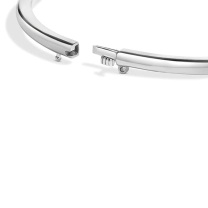 Close-up angled view of an open white bracelet with a single round red gemstone set in a bezel setting near the clasp.