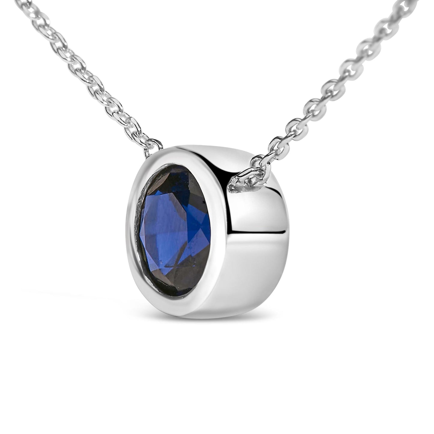 Close-up front angle of a white metal necklace with a round blue gemstone in a bezel setting.