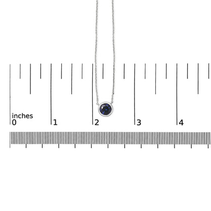 White necklace with a round blue gemstone in bezel setting, shown on a scale, top-down view.
