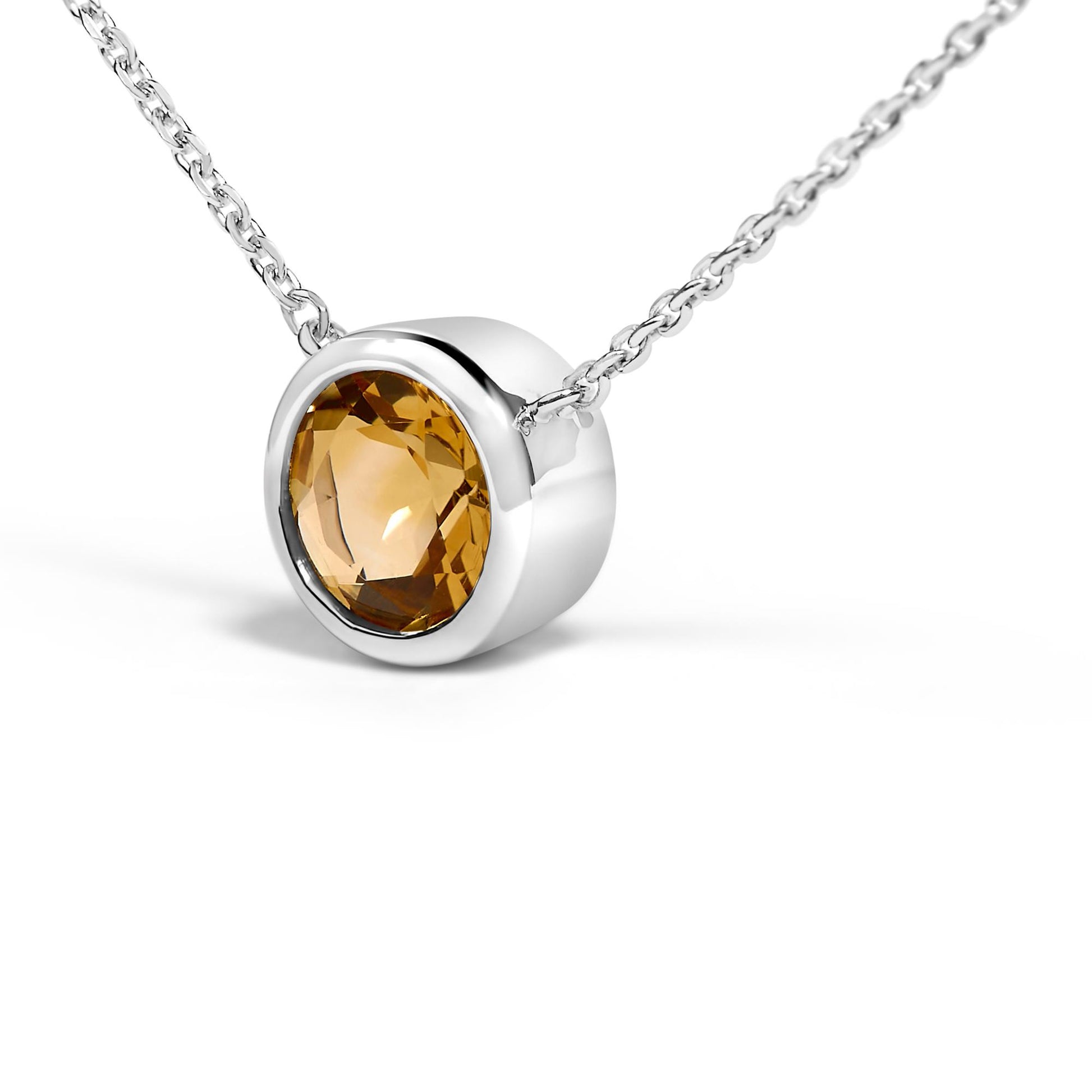 Close-up front angle of a white metal necklace featuring a round yellow gemstone in bezel setting.