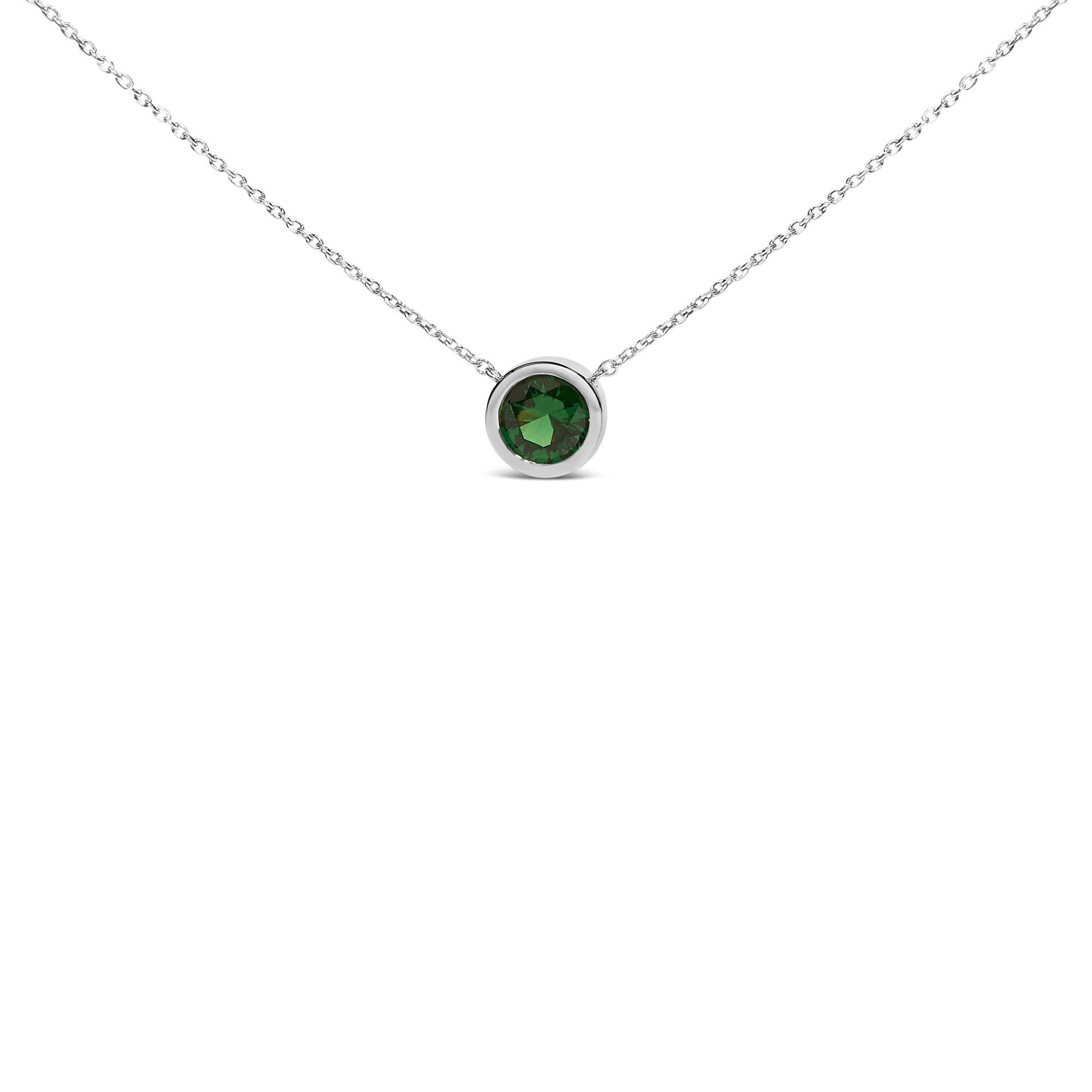 Close-up front view of a white necklace with a single round green gemstone in a bezel setting.