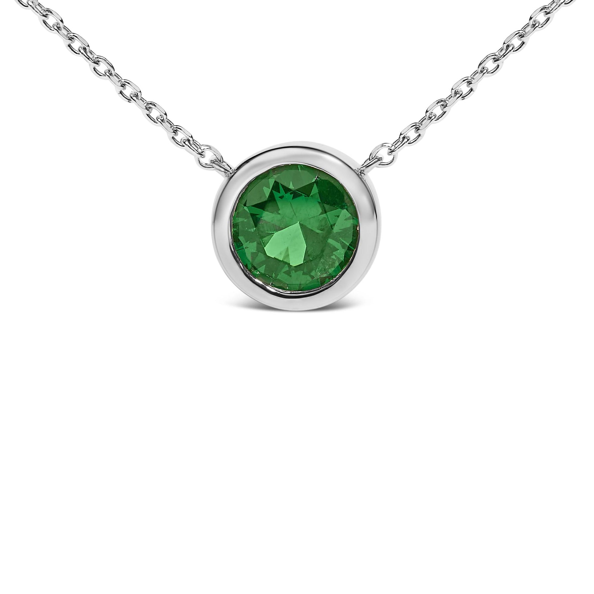 Close-up front view of a white necklace featuring a round green gemstone in a bezel setting.