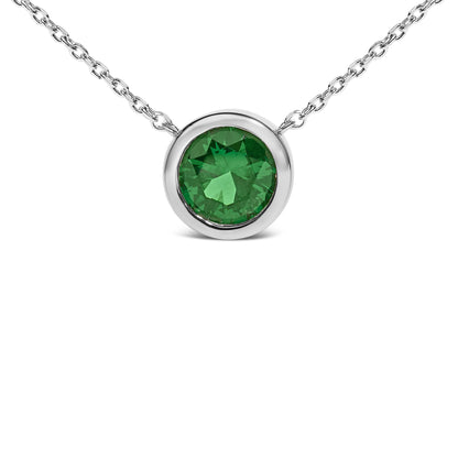 Close-up front view of a white necklace featuring a round green gemstone in a bezel setting.
