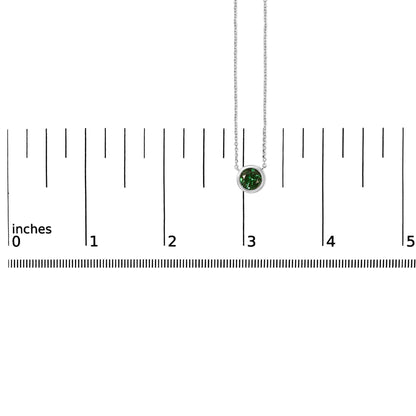 White necklace with a round green gemstone in bezel setting, shown hanging on a ruler for scale, front view.