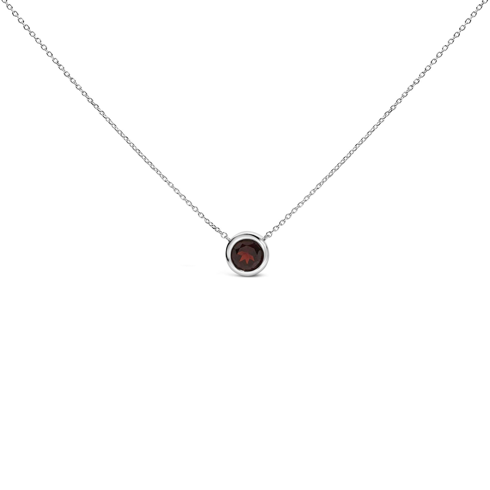 Front view of a white necklace with a round red gemstone set in a bezel setting on a chain, isolated on white background.