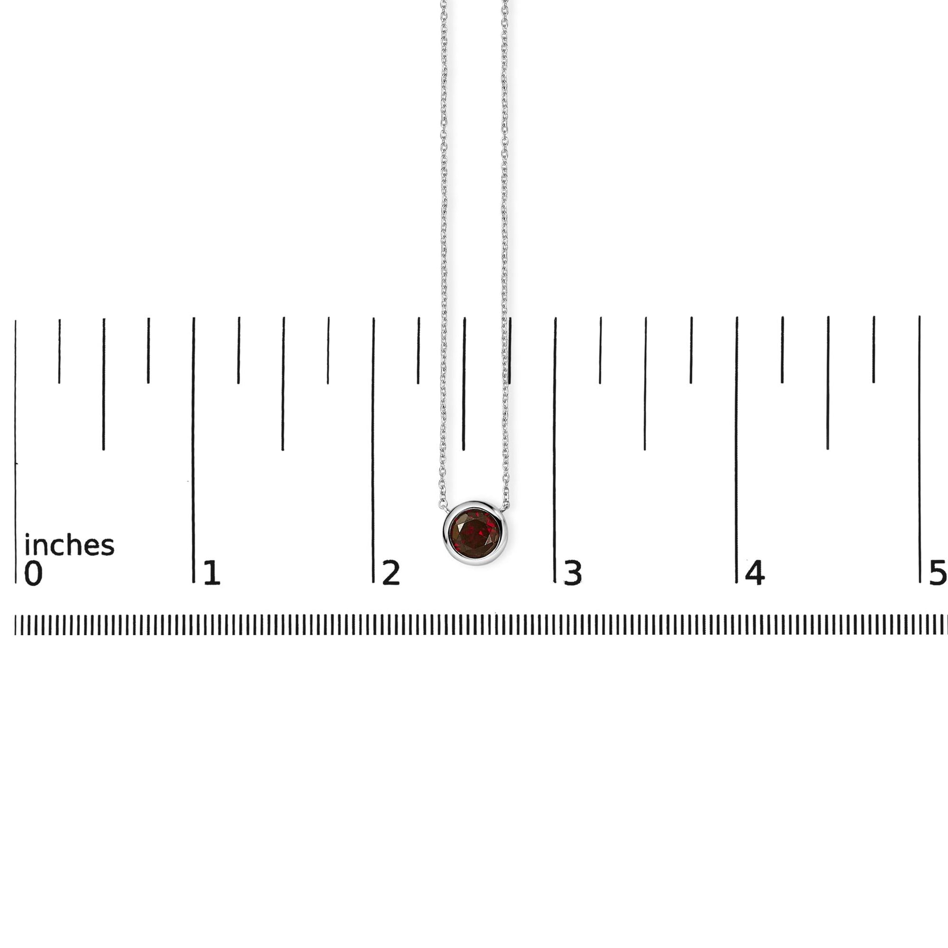 White necklace with round red gemstone in bezel setting shown on a ruler scale, front view.