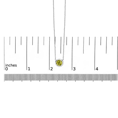 White necklace with a round green gemstone in bezel setting, shown hanging on a scale with the pendant centered, shot from the front.