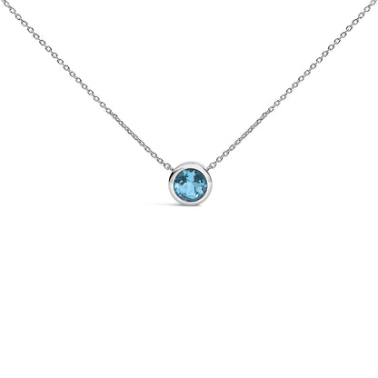 Close-up front view of a white necklace with a single round blue gemstone in a bezel setting centered on a delicate chain.