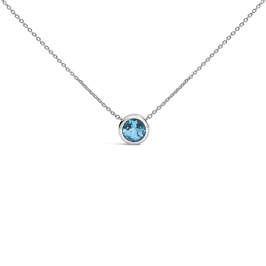 Close-up front view of a white necklace with a single round blue gemstone in a bezel setting centered on a delicate chain.