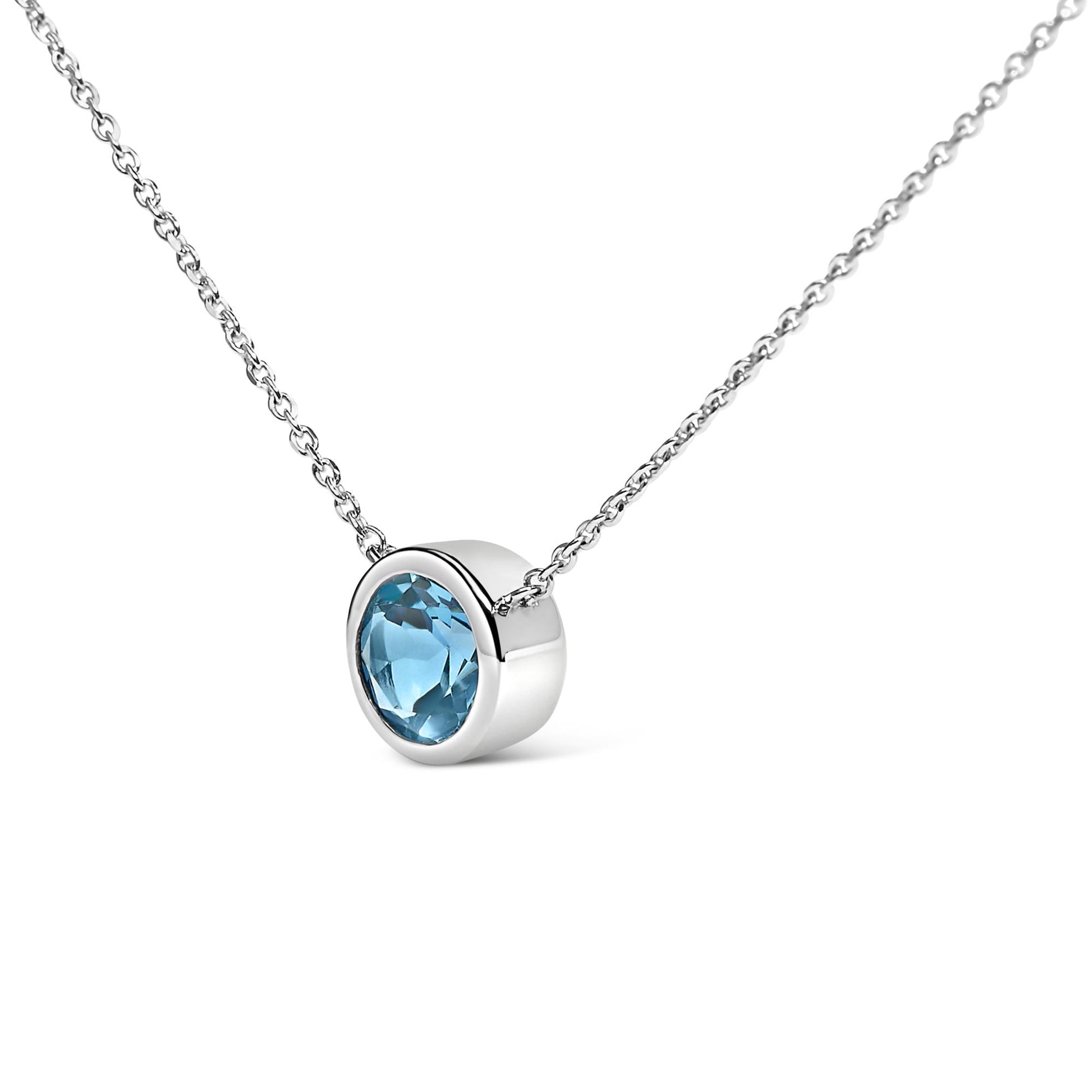 White necklace with a round blue gemstone in a bezel setting, shown in a close-up angle.