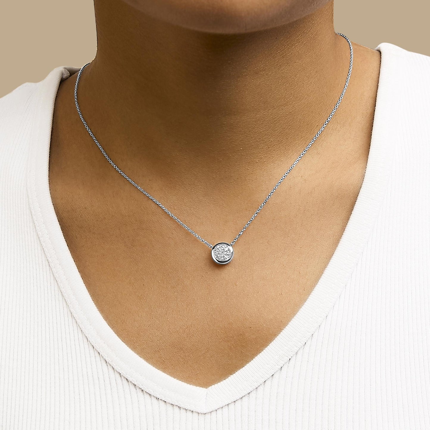 White metal necklace with a round white gemstone in a bezel setting, shown worn on a model, front close-up angle.