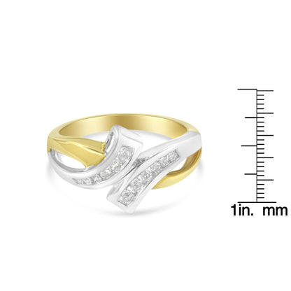 Two-toned ring with a curved design featuring channel-set round white gemstones, shown from a front angle, placed next to a ruler for size reference.