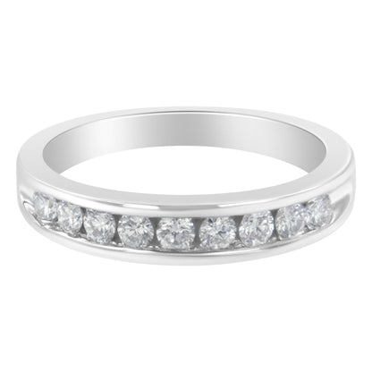 Front angle of a white metal ring featuring a channel setting of round white gemstones.
