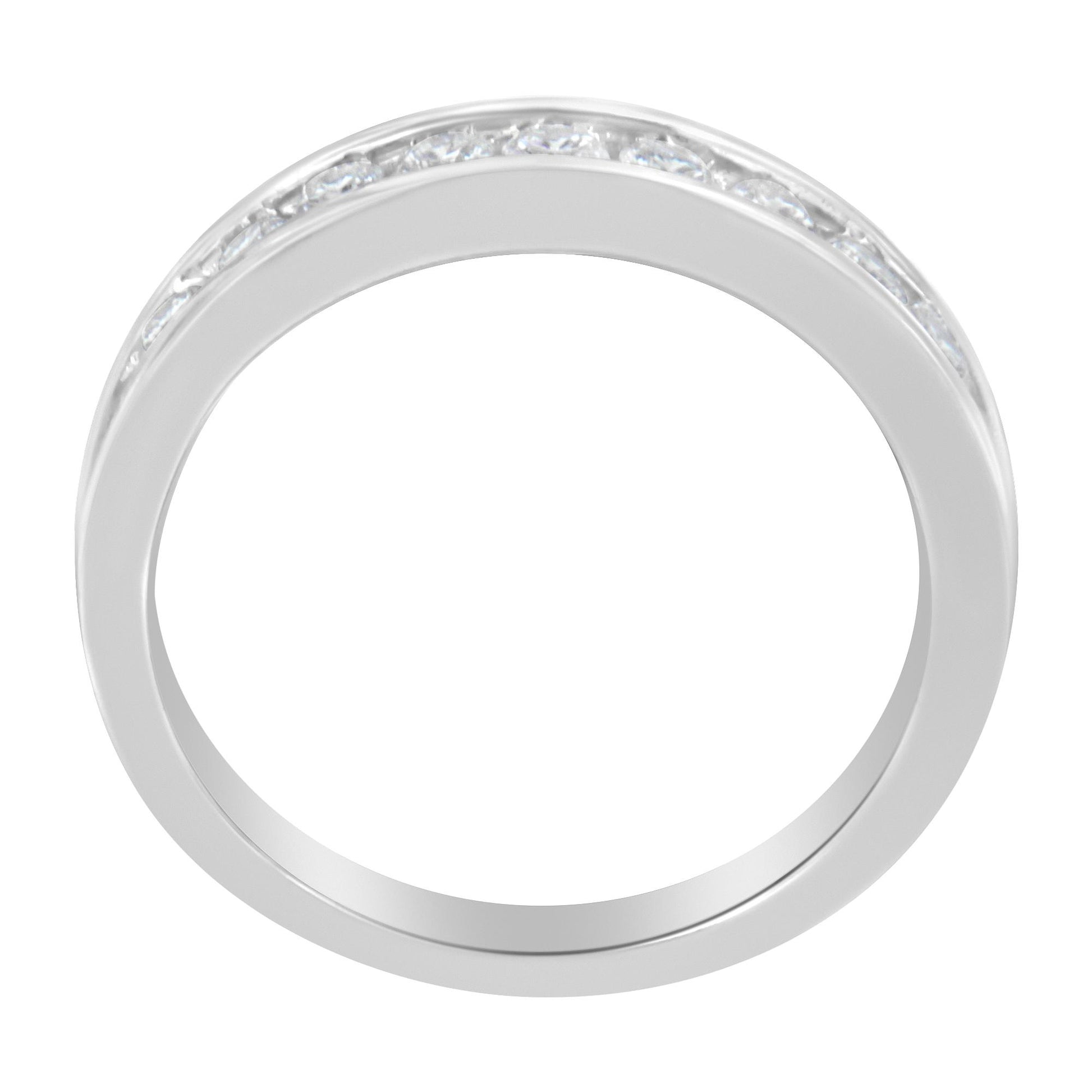 Top-down view of a white ring with a channel setting featuring round white gemstones encircling part of the band.