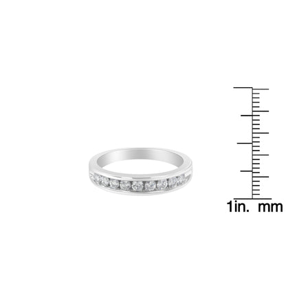 Front angled view of a white ring with a channel setting of round white gemstones, displayed next to a ruler for size reference.