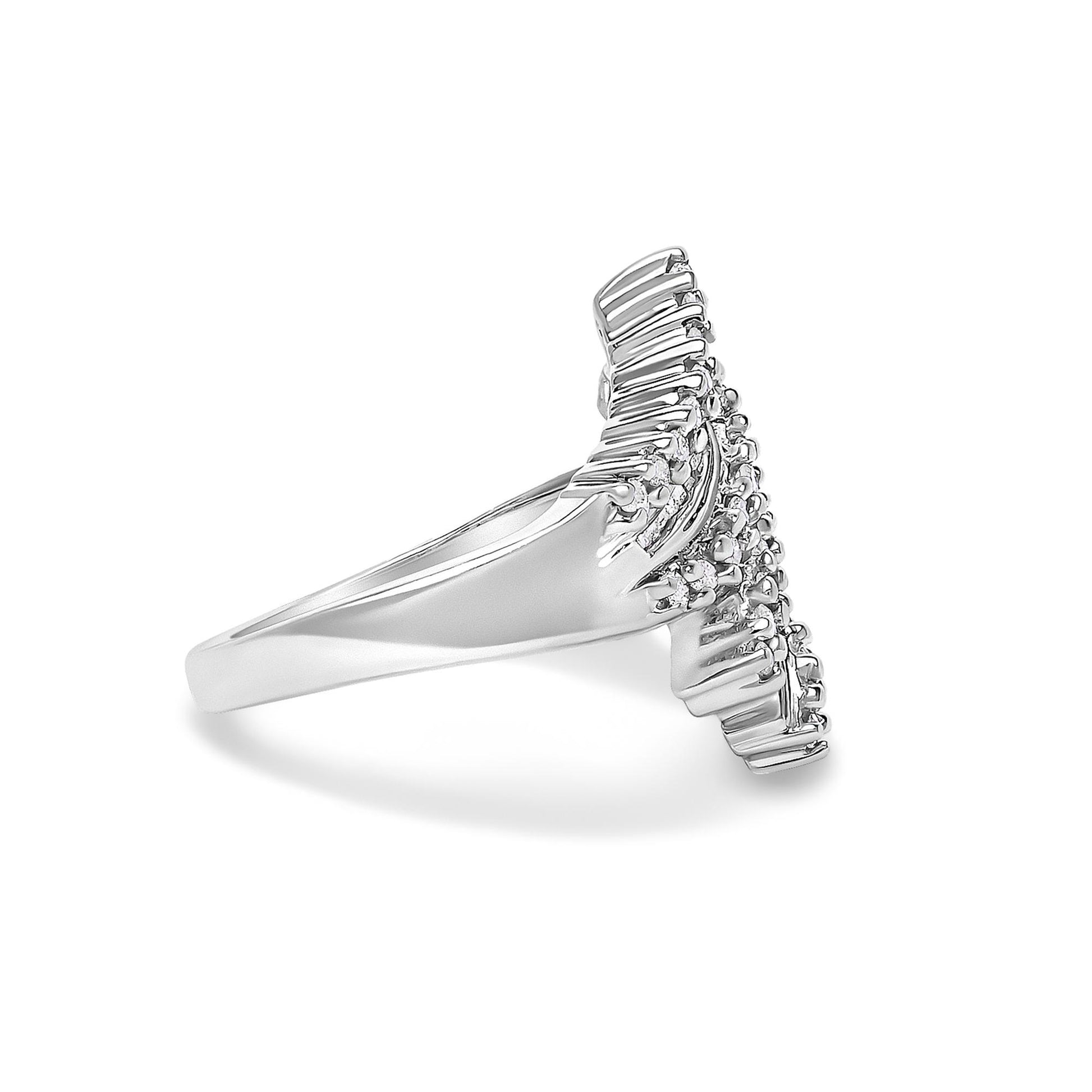 White metal ring shown from the side angle with a V-shaped top featuring round white gemstones in prong settings and baguette white gemstones in channel settings.