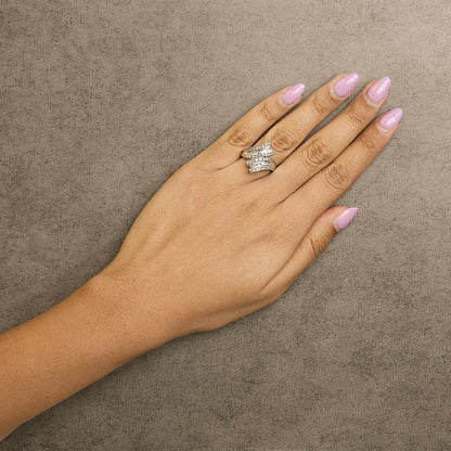 White metal ring with round white gemstones in prong setting and baguette white gemstones in channel setting, shown worn on a model's hand, top view.