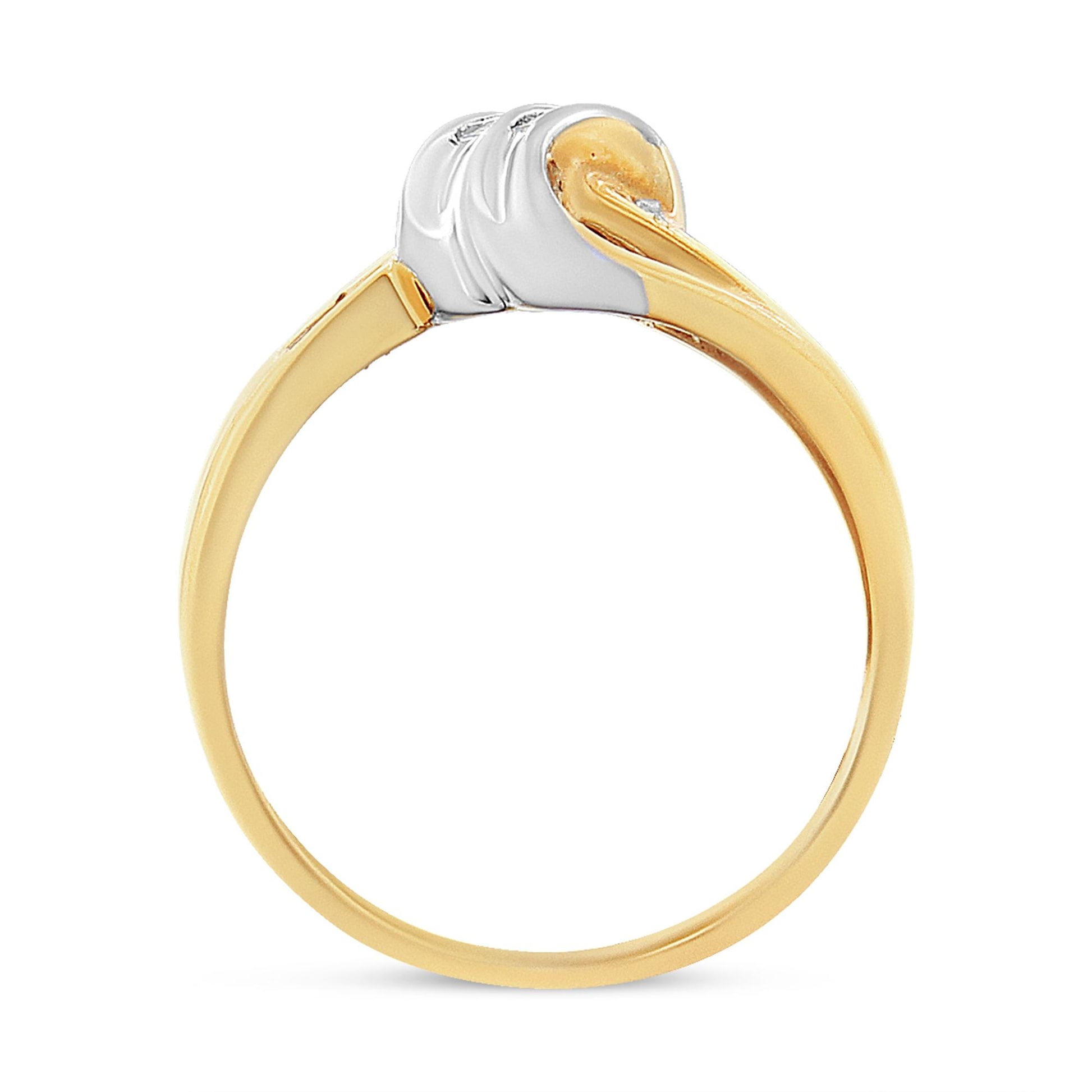 Two-toned ring viewed from the side with round and baguette white gemstones in channel settings.