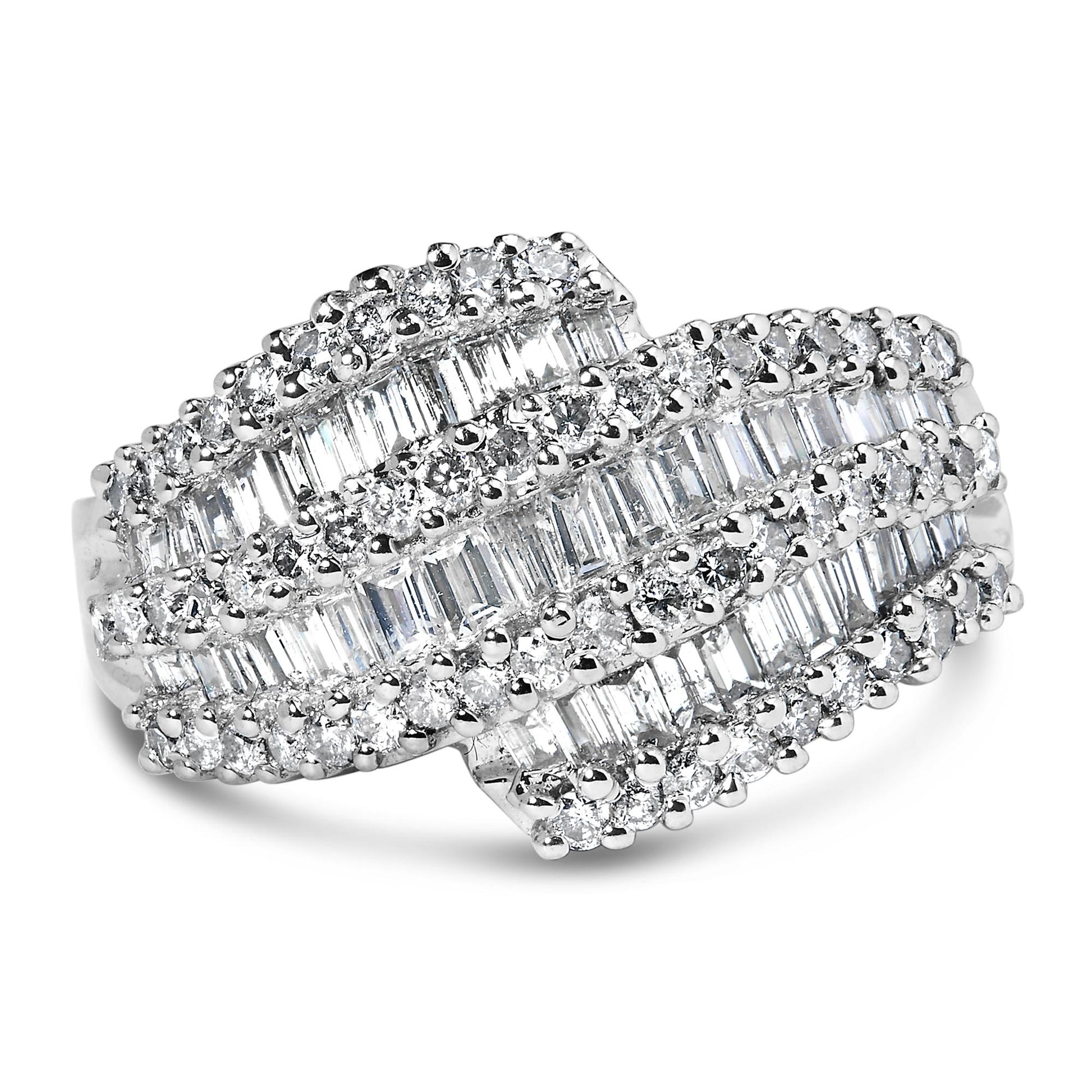 Close-up of a white metal ring with overlapping rows of channel-set baguette-shaped white gemstones and prong-set round white gemstones, shown from a front angle.