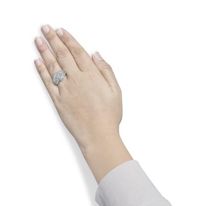 White metal ring with multiple rows of white round prong-set gemstones and baguette channel-set gemstones, worn on a model's hand, shown from top angle.