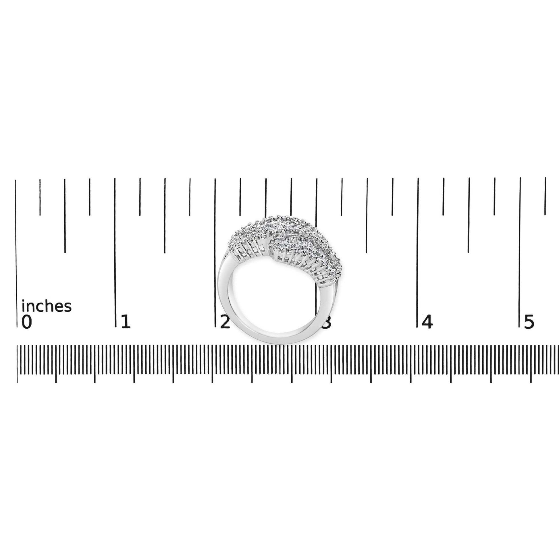Top-down view of a white metal ring with two curved rows of white round gemstones in prong settings and multiple rows of white baguette gemstones in channel settings, placed on a ruler for size reference.