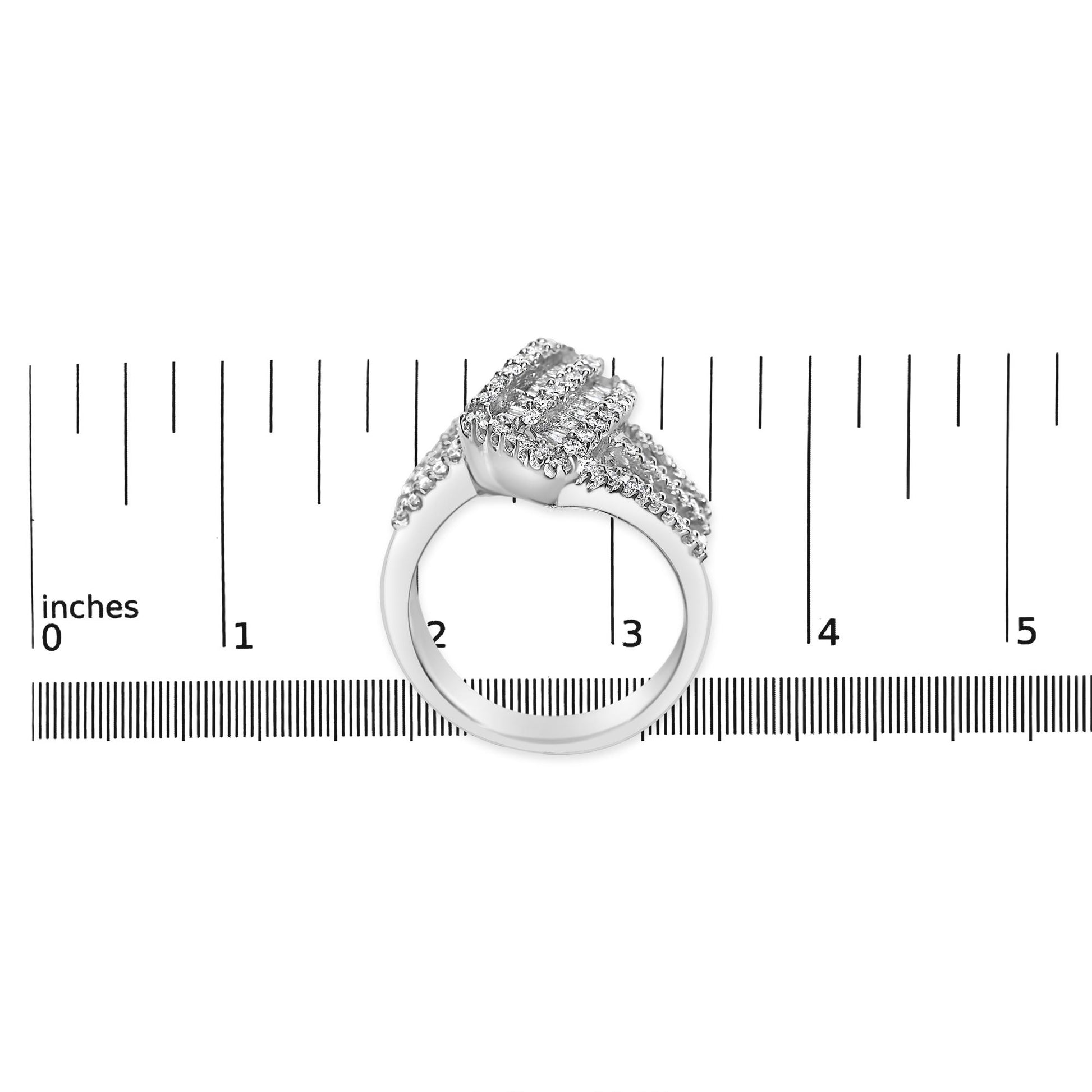 White metal ring with round and baguette shaped white gemstones, shown from the side on a ruler for size reference.