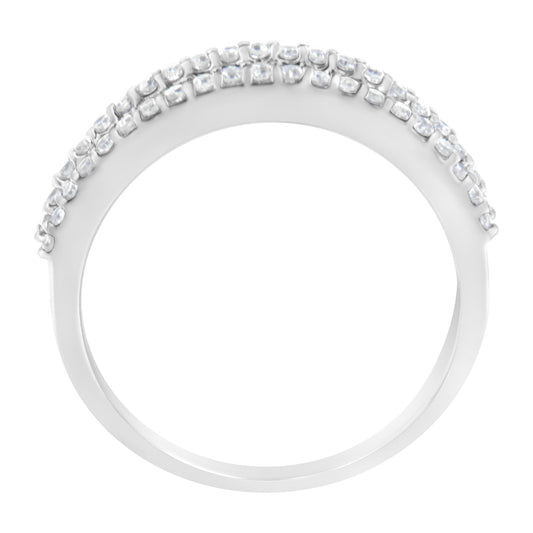 White metal ring with two rows of white round prong-set gemstones on top and a row of white baguette channel-set gemstones beneath, shown in a close-up side angle.