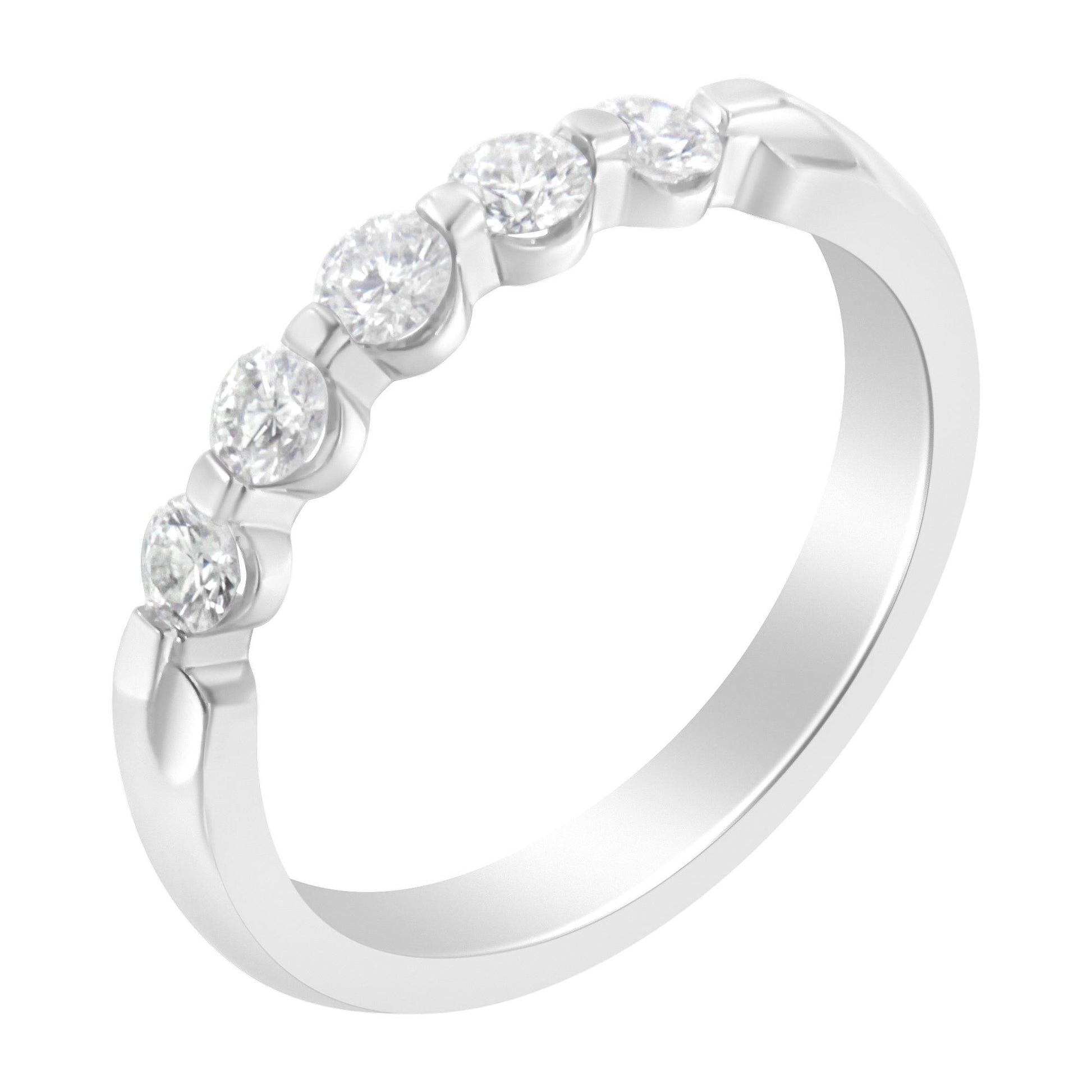 White metal ring with five round white gemstones in a channel setting, shown at a slight angle.
