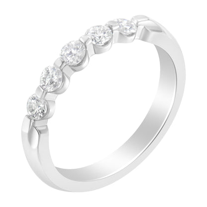 White metal ring with five round white gemstones in a channel setting, shown at a slight angle.