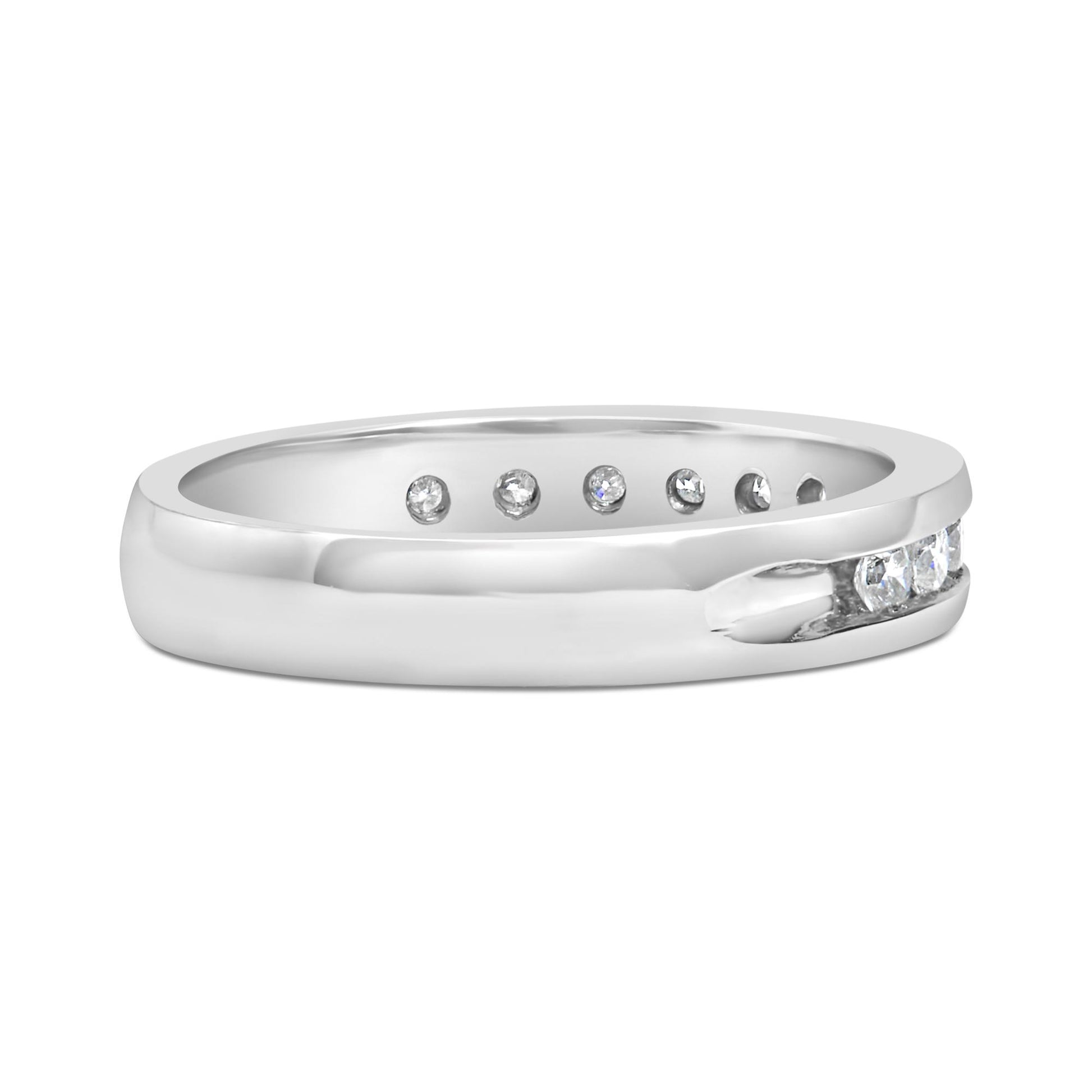 White metal ring with a partial channel setting of round white gemstones, shown from a side angle.