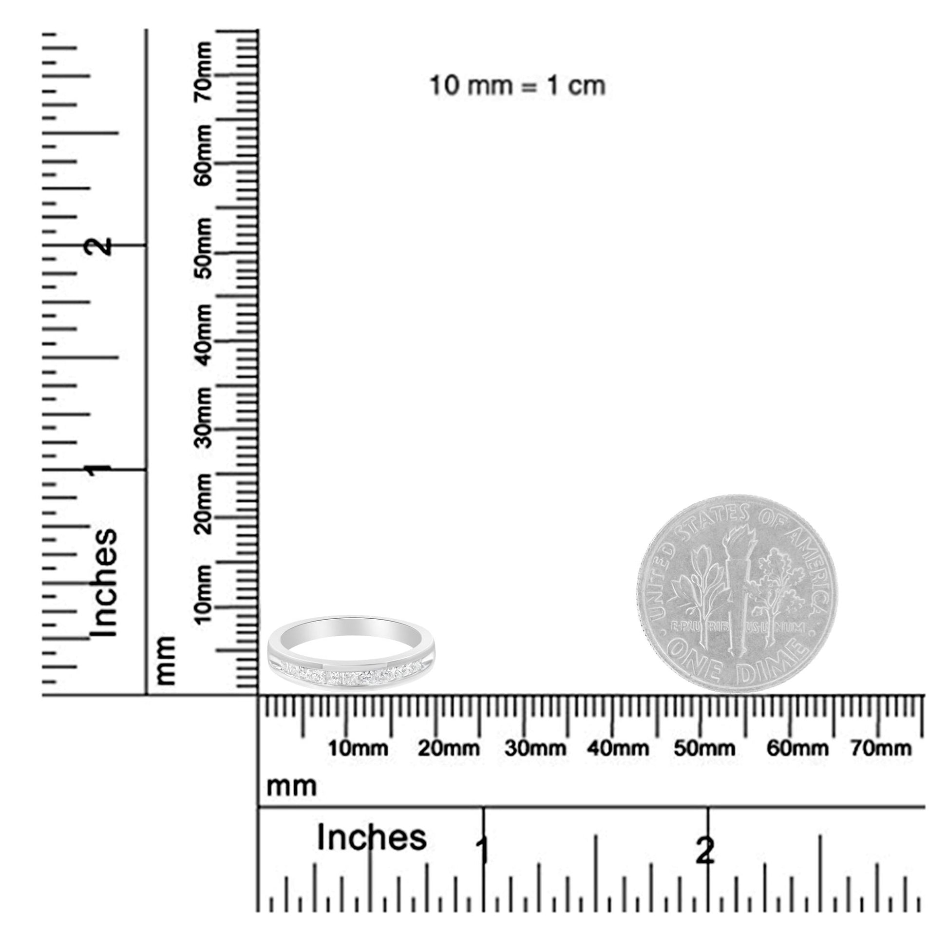 Close-up of white metal ring with channel-set princess-shaped white gemstones, shown on a ruler for size reference.