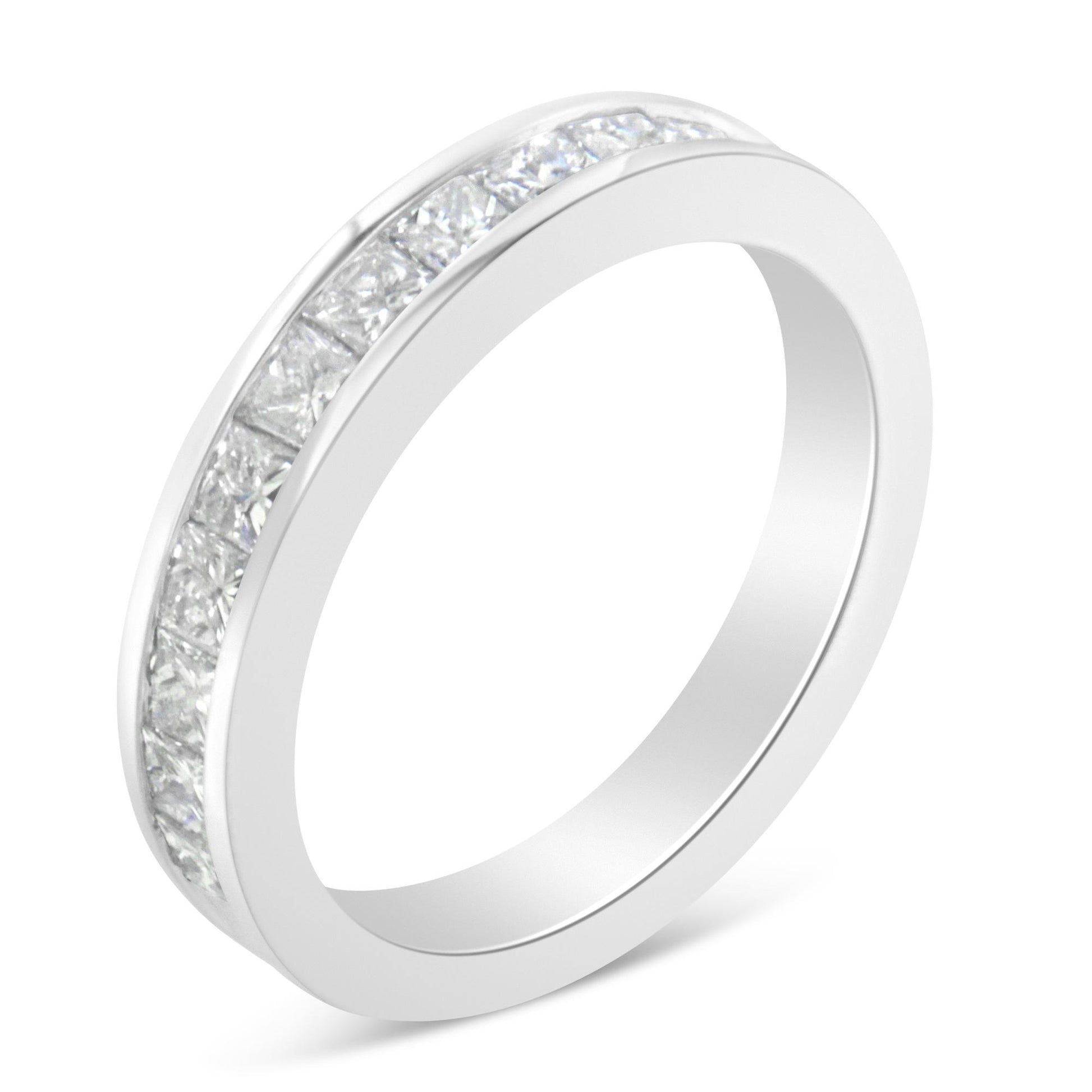 Close-up angled view of a white metal ring featuring a channel setting of princess-shaped white gemstones around the band.