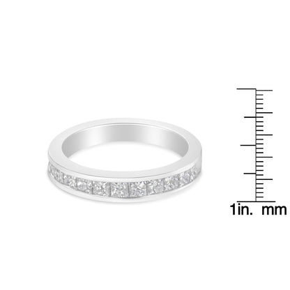 White metal ring with channel-set princess-shaped white gemstones viewed from a slight side angle, shown next to a ruler for size reference.