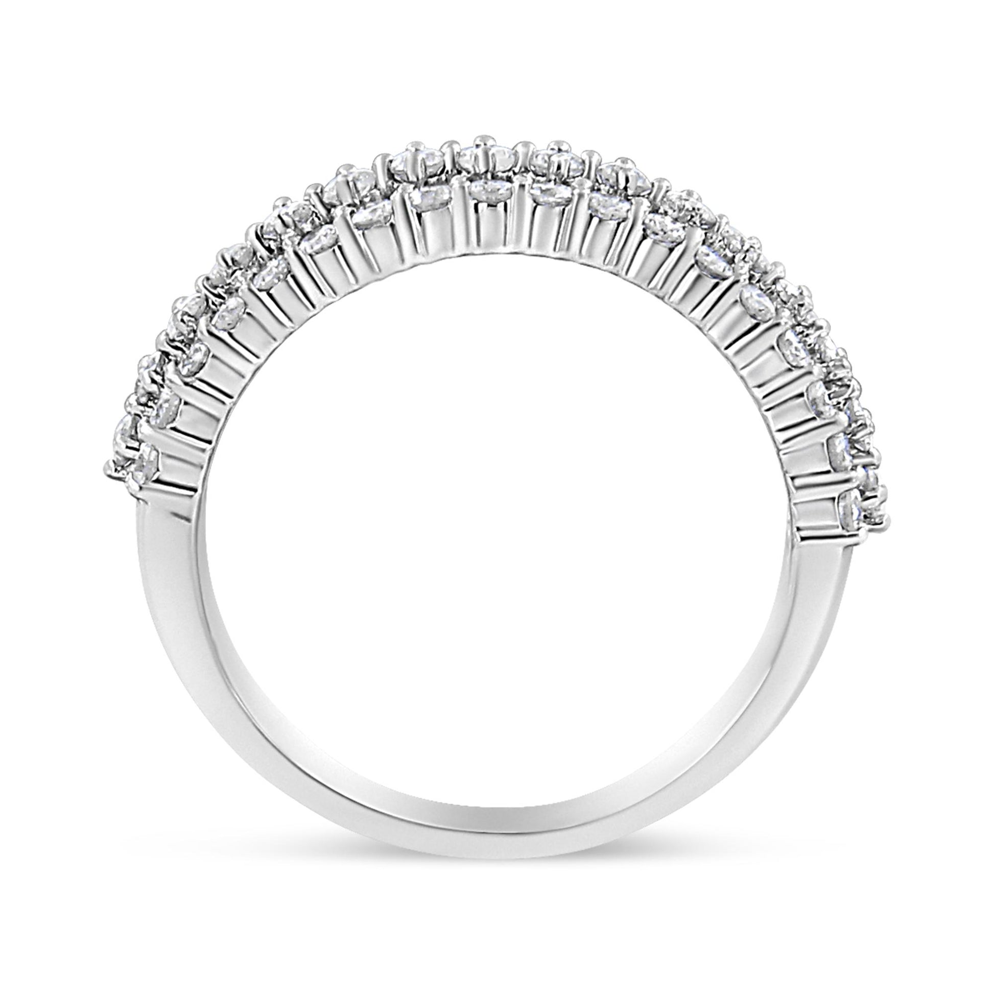 Side angle view of a white metal ring featuring a row of round white gemstones in prong settings along the band.