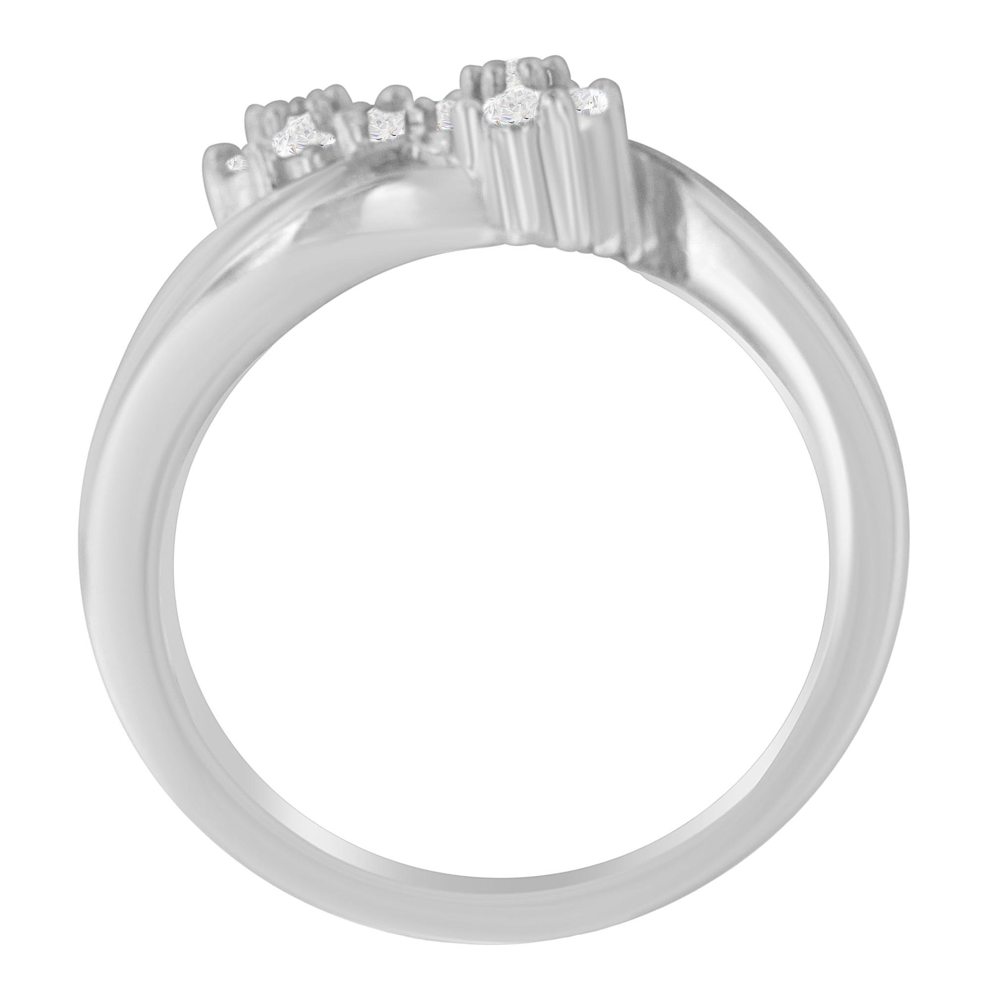 White metal ring with round and baguette-shaped white gemstones in prong and channel settings, shown in a close-up side angle.