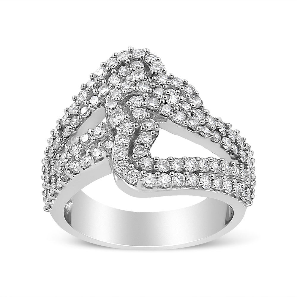 Front angled view of a white metal ring with multiple rows of round white gemstones in prong settings forming an intertwined design.