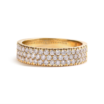 Yellow metal ring with three rows of round white gemstones in pave setting, shown in close-up side angle.