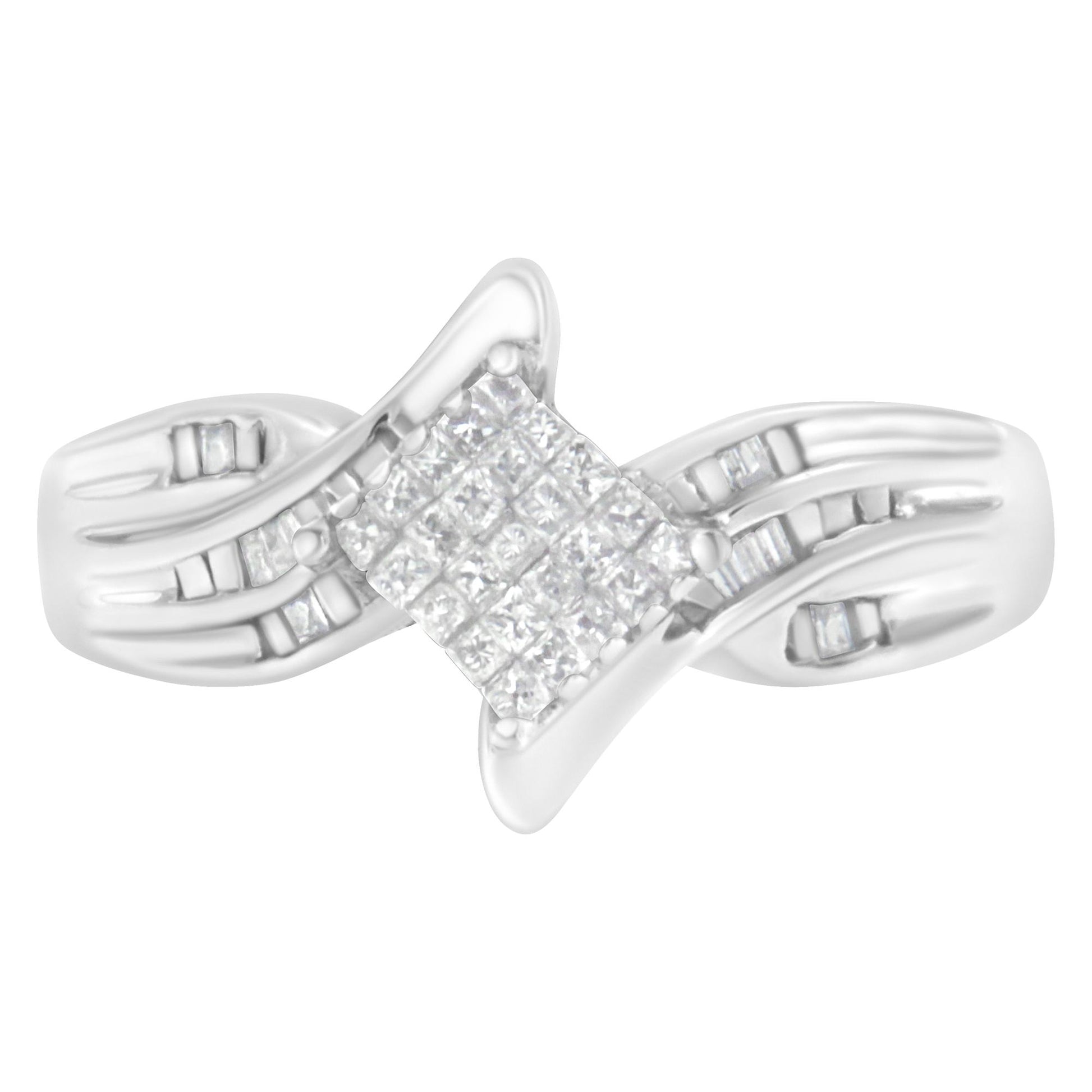Front angle of a white metal ring featuring a central cluster of princess-shaped white gemstones in an invisible setting, flanked by baguette-shaped white gemstones in a channel setting along the band.