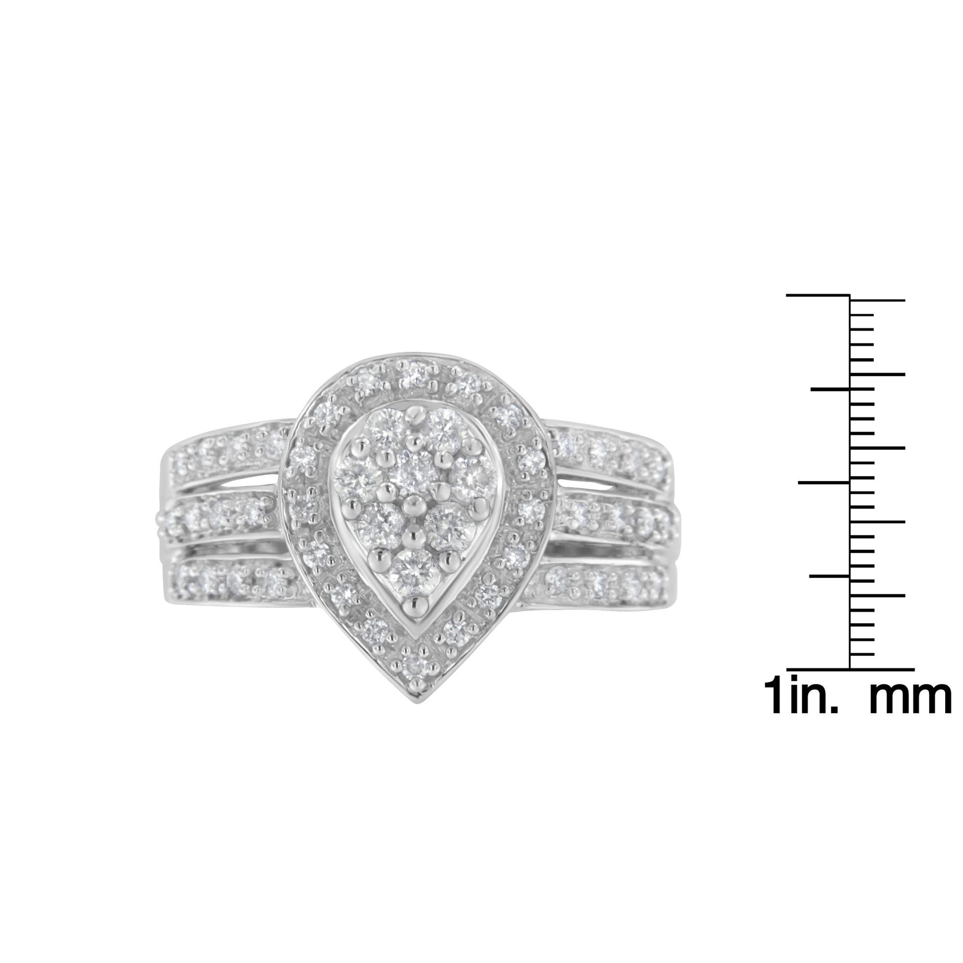 Front view of a white metal ring with a teardrop-shaped cluster of round white gemstones in pave setting, displayed next to a scale for size reference.
