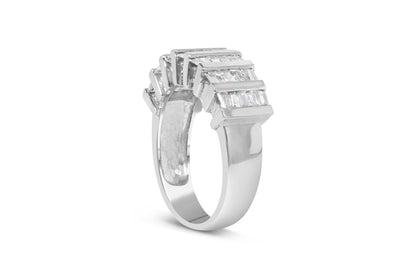 White metal ring with channel set baguette-shaped white gemstones, side angled view.