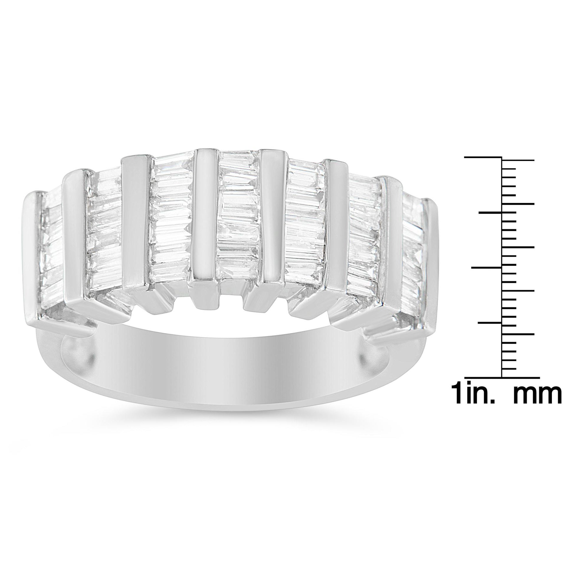 White metal ring with multiple rows of vertically set baguette-shaped white gemstones in a channel setting, shown from a front angle, placed next to a ruler for size reference.